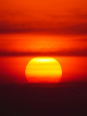 Beautiful big sunset over sea. Tranquil scene of Closeup red sun and red sky sunset over the ocean