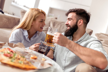 Young couple eating pizza at home