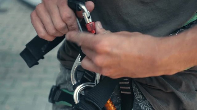 Three section clips of male attaching lock to harness & clipping lock on safety helmet for high altitude climbing.