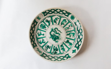 a white round plate with floral and line pattern on white background