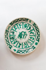 a white round plate with floral and line pattern on white background