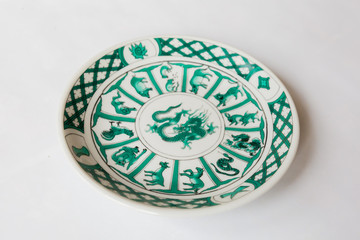 a white round plate with floral and line pattern on white background