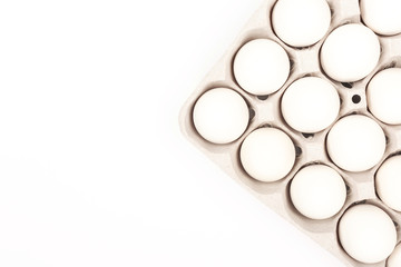 Eggs in egg box on white background
