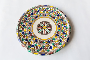 a white round plate with floral and line pattern on white background