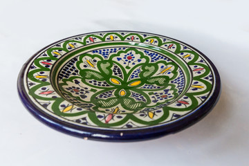 a white round plate with floral and line pattern on white background