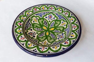 a white round plate with floral and line pattern on white background