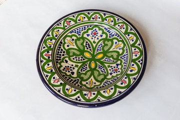 a white round plate with floral and line pattern on white background