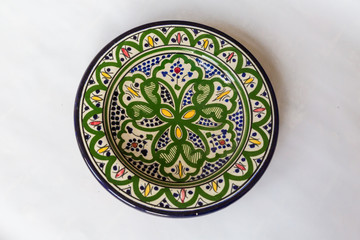 a white round plate with floral and line pattern on white background