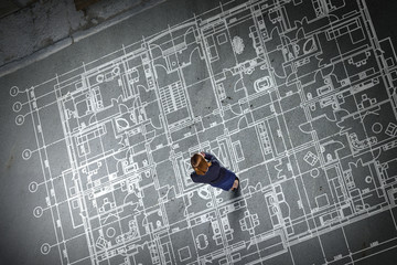 Woman engineer thinking over his plan. Mixed media