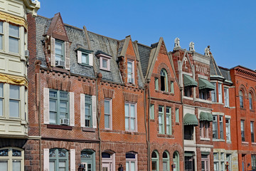 row of old townhouses with gables and brownstone trim