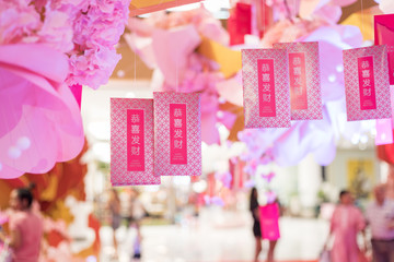 Obraz na płótnie Canvas many chineses money packet hang on pink fake flower tree in the mall