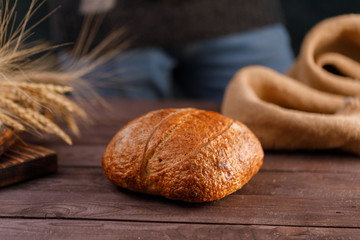 Craft bread close-up in the hand of a man and flour poured on the bread. The concept of healthy food and traditional bakery.