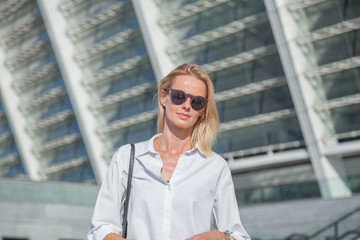 Business woman in a white shirt crossed her arms over her chest against of modern building