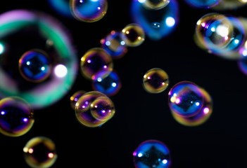 Beautiful colorful soap bubbles float in the dark.