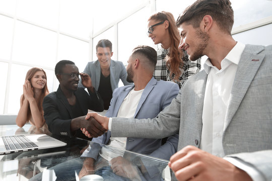 multinational colleagues at the office smiling at the table