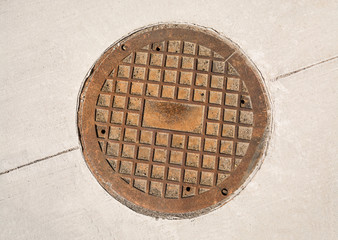 Cast iron manhole hatch on concrete pavement