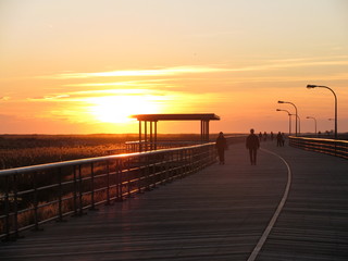An orange and yellow sunset at Jones Beach boardwalk in Long Island, New York.