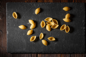Fototapeta na wymiar Conchiglie shells pasta on a shale cutting board