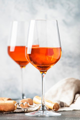 Trendy food and drink, orange wine in glass, gray table background, space for text, selective focus