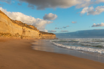 Empty beach coastline view with rock cliff on the side.