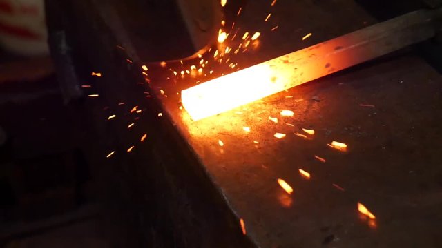 Blacksmithing in Slow Motion to Forge a Taper on a Hot Metal Bar in the Blacksmith Shop