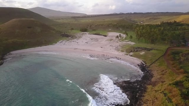 Aerial drone footage Anakena Beach an amazing, idyllic and wild beach in the Pacific Ocean at Easter Island an amazing travel destination with the Moais mystery like Ahu Nau Nau in Anakena beach 3/4