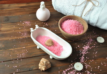 Dead Sea cosmetics. Spa and body care products. Aromatic rose bath Dead Sea Salt on the dark wooden background. Natural ingredients for homemade body salt scrub. Beauty skin care. 