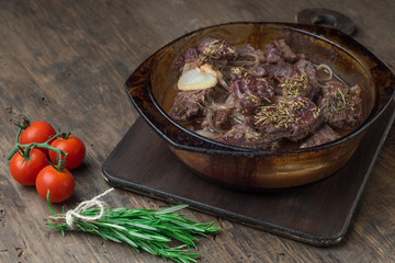 Goulash, beef stew in glass  baking dish on dark background,