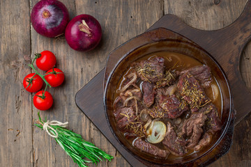 Goulash, beef stew in glass  baking dish on dark background,