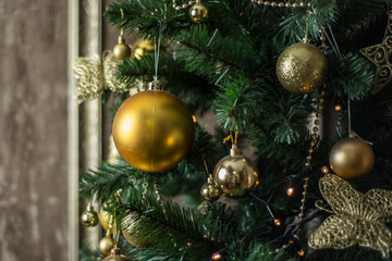 New Year's greased spruce is decorated with golden decorative balls and accessories