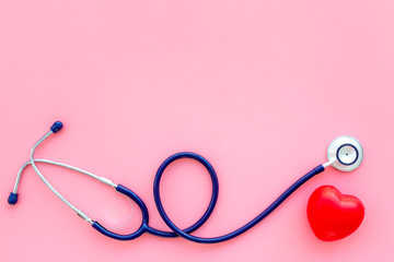 Heart health, health care concept. Stethoscope near rubber heart on pink background top view space...