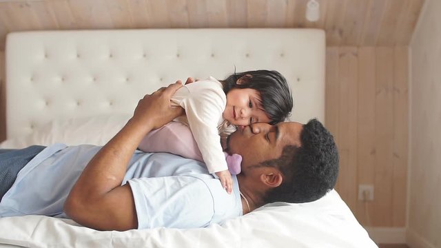 African american cute little girl having playful time with daddy.