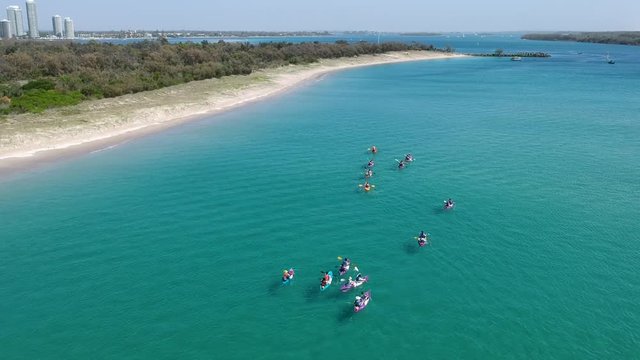 A large group of kayaks exploring the coastline