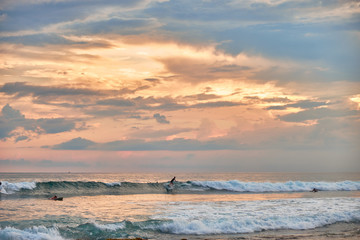 Stunning sunset on the beach overlooking the ocean and the waves. 