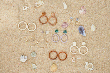Fototapeta na wymiar Handmade Jewelry on Sand Beach Top Down View