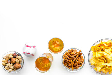 Snacks for watching american football on TV. Watching sports. Chips, nuts, rusks near beer and ball on white background top view copy space