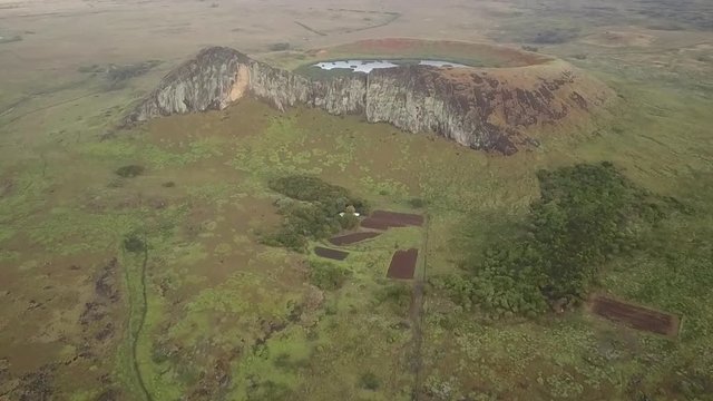 Aerial footage view over Rano Raraku Crater Lake Moais quarry where were built, some Moai still stay on the quarry waiting to one day reach there final destination, awe landscape at Easter Island