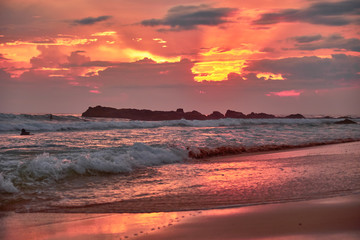 Obraz premium Stunning sunset on the beach overlooking the ocean and the waves. 