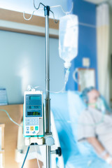 Infusion pumps with blurry patient in hospital.