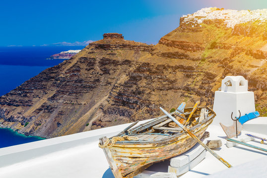 Vintage wooden boat close up against the background of the Santorini volcanic landscape