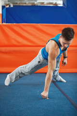 Fototapeta na wymiar fitness, sport, people and lifestyle concept - man doing one arm push-ups on one finger in gym
