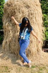 Asia thai woman travel visit and standing posing for take photo with straw stack in public garden park