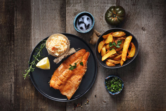 Grillowany pstrąg z sur&oacute;wką i pieczonymi ziemniakami.