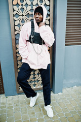 Stylish urban style african american man in pink hoodie posed. Afro rapper guy.