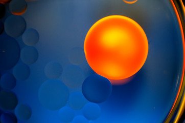big yellow orange ball on blue background with circles - 247914031