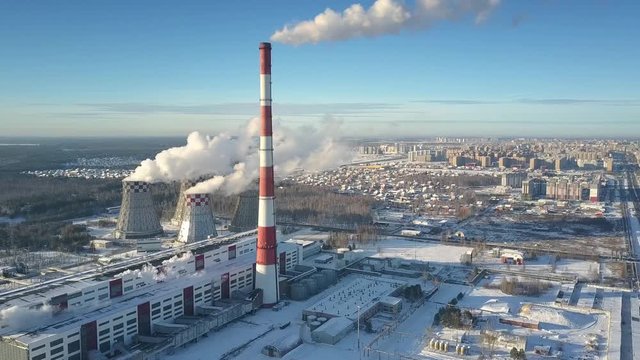 amazing upper view winter heating station with towers and chimney against modern town and sky