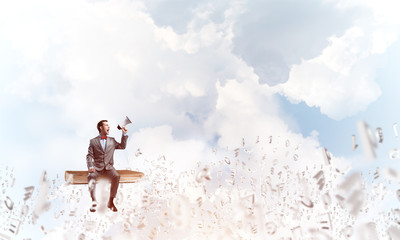 Businessman announcing something in loudspeaker and symbols fly around in air