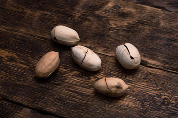 Pecan nuts on a brown wooden board background.
