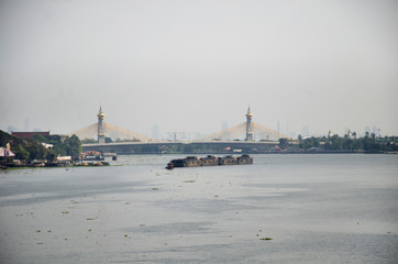 Fototapeta na wymiar Asian thai people sailing barge and tugboat cargo ship in Chao Phraya or chaopraya river from Bangkok go to Ayutthaya in Nonthaburi, Thailand