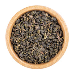 Milk oolong green tea leaves in wooden bowl isolated on white. Top view.